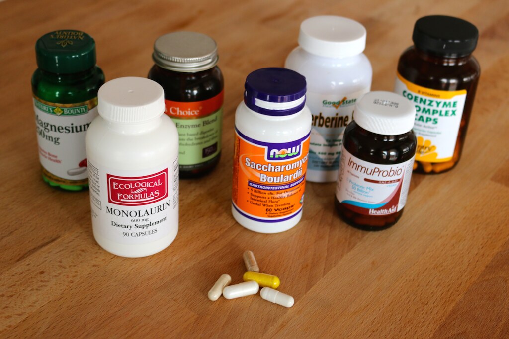 Probiotics for gut health UK - bottle of probiotic capsules on a wooden surface with green leaves