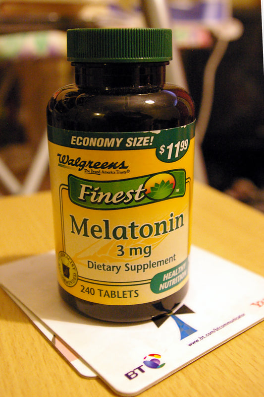 Melatonin 10 mg fast dissolve tablets on a wooden table near a glass of water