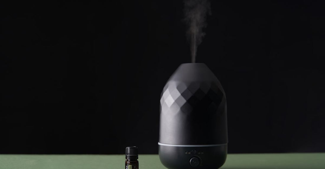 An ultrasonic aromatherapy diffuser for essential oils releasing a fine mist in a modern home setting.