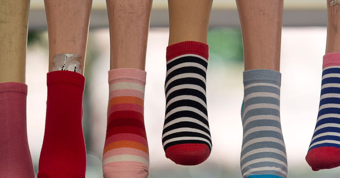 A selection of cushioned insoles and moisture-wicking socks laid out on a neutral surface, illustrating the socks & insoles buying guide UK essentials.