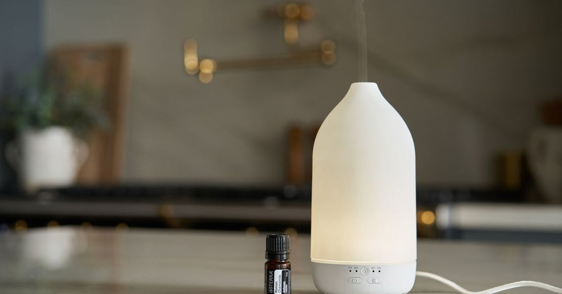 A sleek ultrasonic aromatherapy diffuser emitting a fine mist, sitting on a wooden shelf, part of a diffusers buying guide UK.