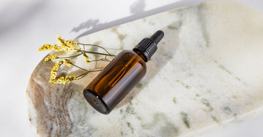 Borage oil bottle and softgel capsules on a white background, showing the golden oil inside.