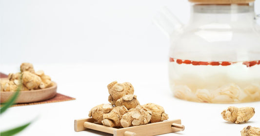 A glass jar of organic ashwagandha root powder with a wooden spoon, next to a capsule bottle, on a light kitchen surface — ashwagandha buying guide UK.
