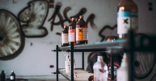 Three sharps containers of varying sizes on a white shelf, illustrating best sharps containers UK 2026 options.