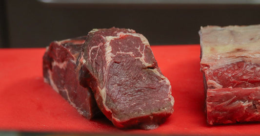 Assorted raw beef cuts on a butcher's block, illustrating a beef buying guide UK for quality meat selection.