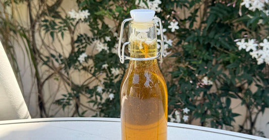 A glass bottle of oregano oil surrounded by fresh oregano sprigs on a white background, illustrating an oregano buying guide UK for Nutrisentra shoppers.