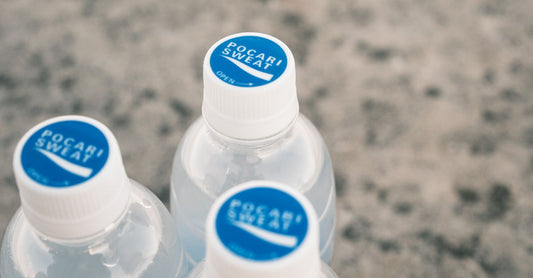 Bottle of electrolyte tablets for runners on a clean surface with a glass of water