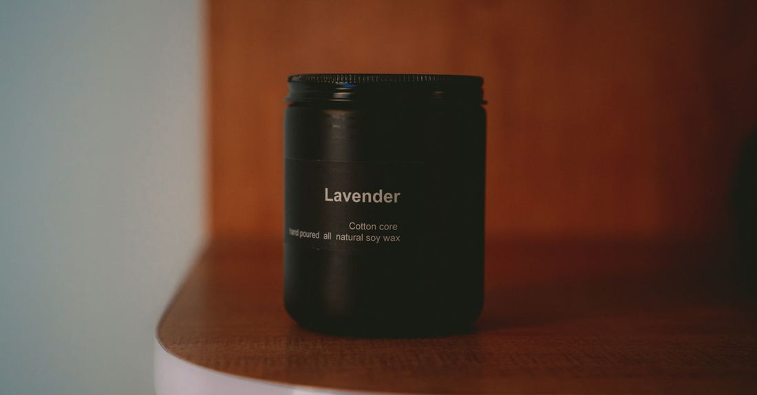 A natural soy wax candle in a glass jar on a wooden shelf, illustrating best candles UK 2026 for clean home fragrance.