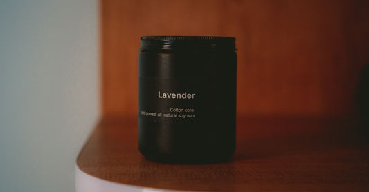 A natural soy wax candle in a glass jar on a wooden shelf, illustrating best candles UK 2026 for clean home fragrance.