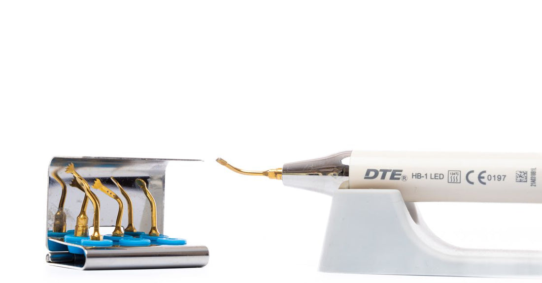 A selection of earwax removal products including drops, an irrigation kit, and a soft silicone ear spoon on a clean white surface, illustrating how to choose earwax removal UK.