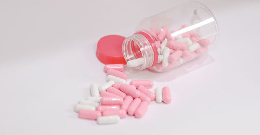 Niacin for cholesterol supplement bottle on a white background with tablets scattered.