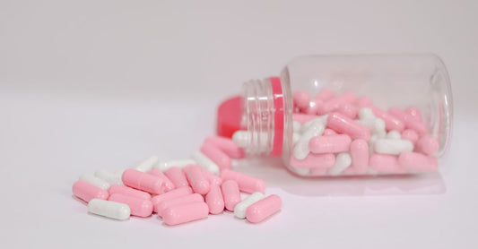 Charcoal capsules for gas displayed in a glass bottle on a neutral surface
