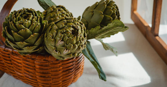 Artichoke supplement capsules and leaves on a neutral background, representing where to buy artichoke online in the UK.