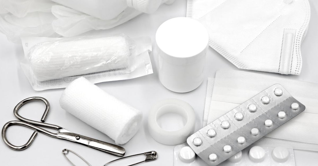 A well-organised first aid kit for home UK with bandages, scissors, and antiseptic cream on a white surface.