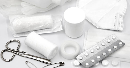A well-organised first aid kit for home UK with bandages, scissors, and antiseptic cream on a white surface.