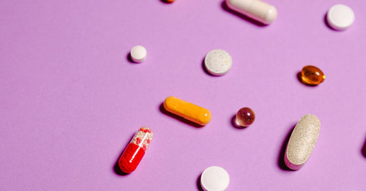A flatlay of colourful multivitamin capsules and softgels on a clean white surface, representing the best multivitamins UK 2026.