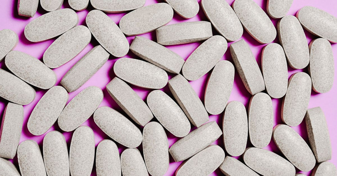 A selection of zinc supplement bottles and capsules on a clean white surface, illustrating how to choose zinc UK.