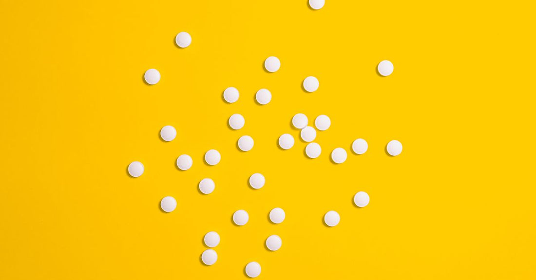 B12 oral sublingual tablets next to a glass of water, illustrating the B12 injections vs oral comparison for UK shoppers.