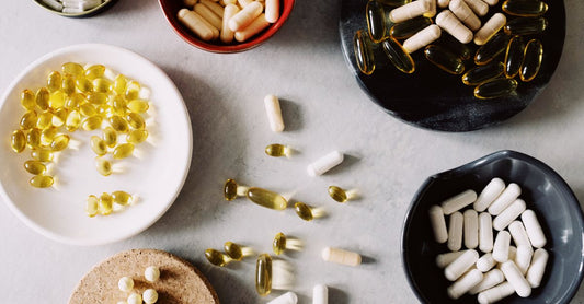Vitamin D supplement bottles and softgels on a white surface, vitamin d buying guide UK