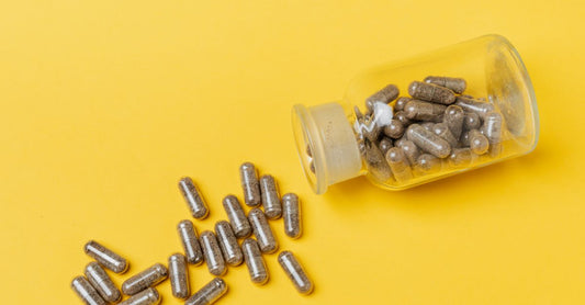 Bottle of quercetin with bromelain supplement capsules on a clean white surface