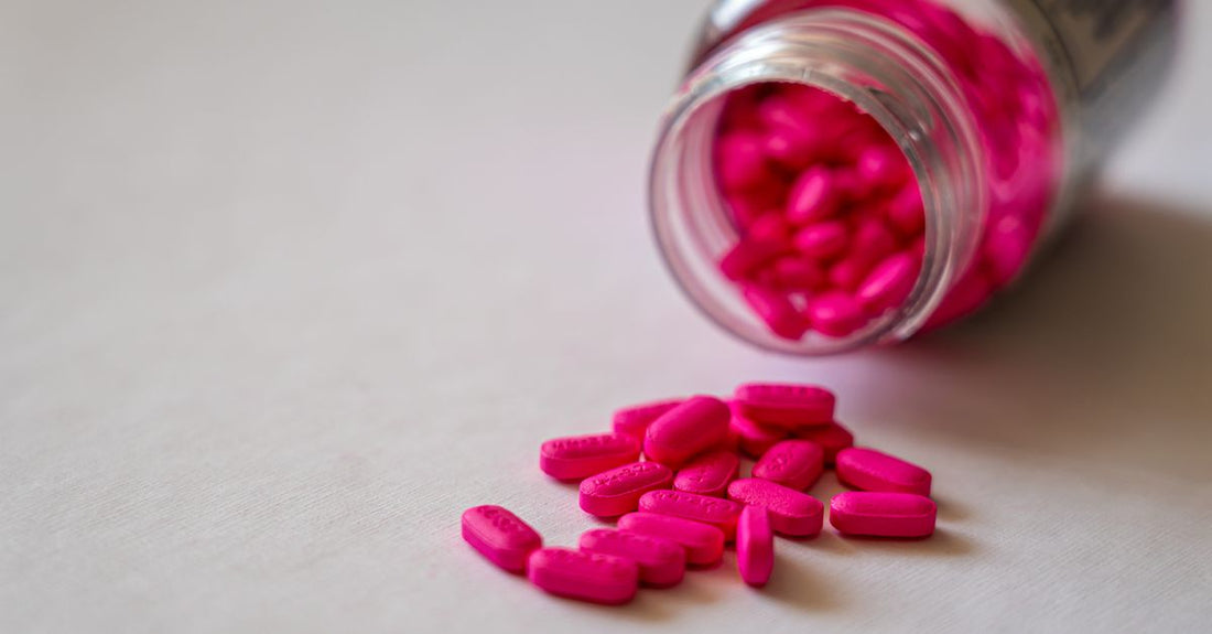 Bottle of vitamin B12 sublingual tablets next to fresh berries, illustrating B12 deficiency symptoms and supplement options.