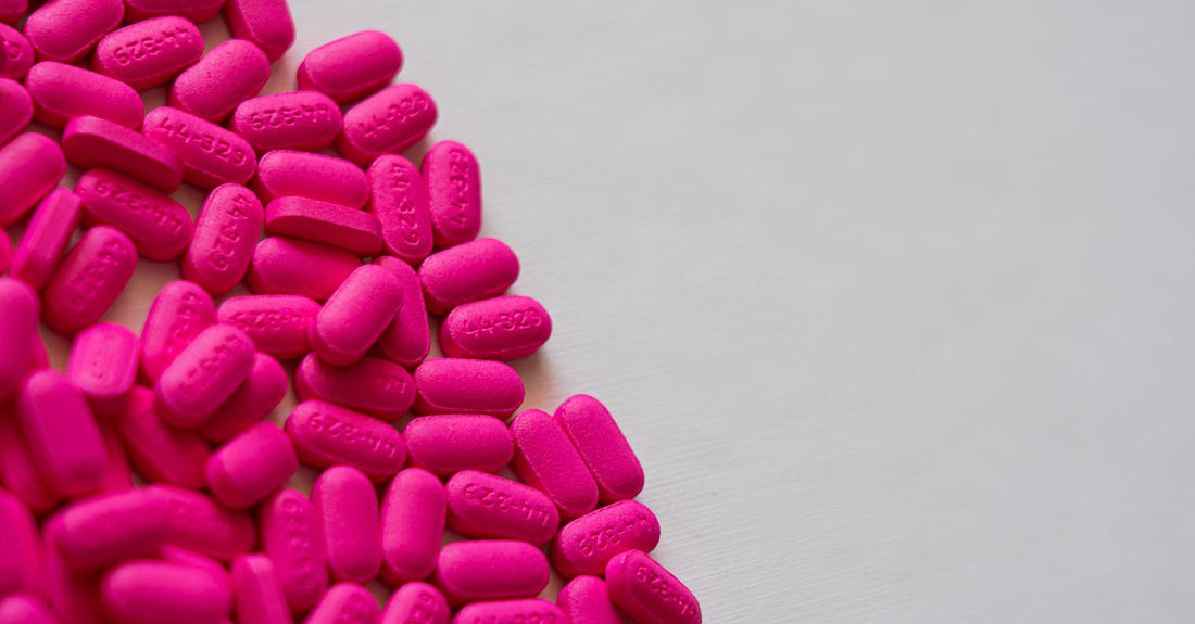 A flatlay of vitamin B12 supplement bottles and capsules on a light background, representing where to buy B12 online.