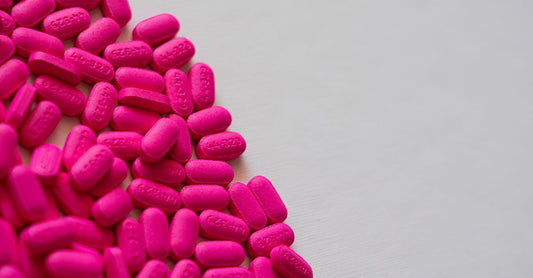 A flatlay of vitamin B12 supplement bottles and capsules on a light background, representing where to buy B12 online.