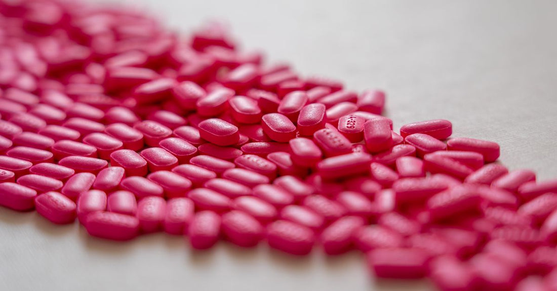 A row of vitamin B12 supplement bottles on a clean white shelf, illustrating where to buy B12 online in the UK.