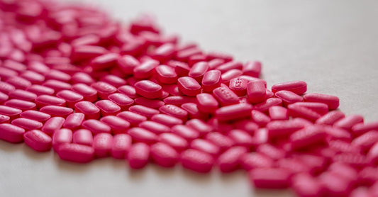 A row of vitamin B12 supplement bottles on a clean white shelf, illustrating where to buy B12 online in the UK.