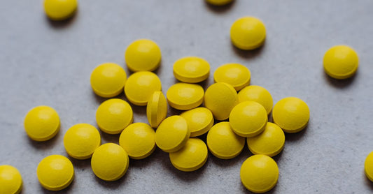 Vitamin C supplements on a clean white background, including tablets and capsules, illustrating a vitamin C buying guide UK.