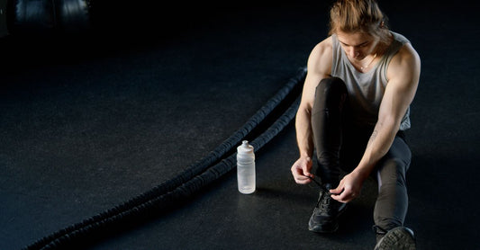 Pre-workout buying guide UK featuring supplement tubs and shaker bottles on a gym bench