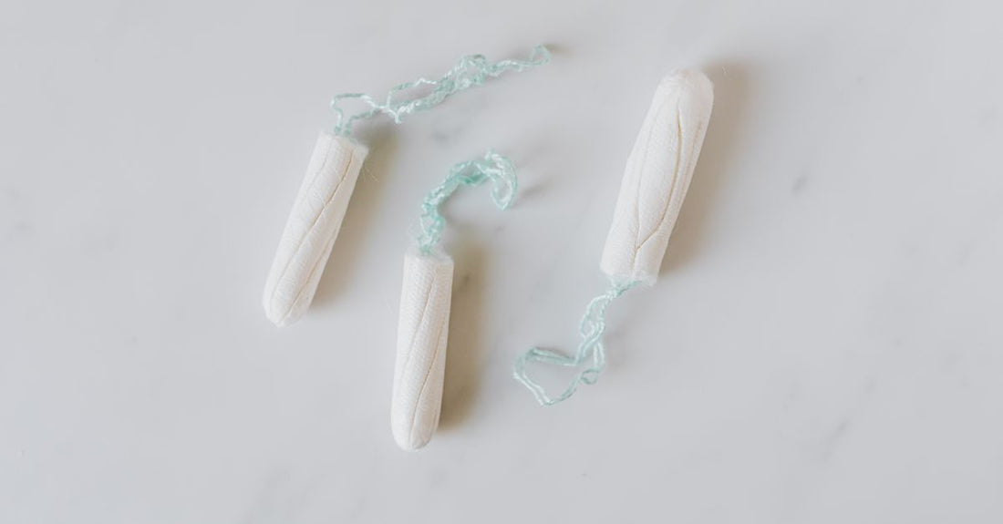 A flatlay of organic cotton tampons with a measuring tape, illustrating a tampons buying guide UK.