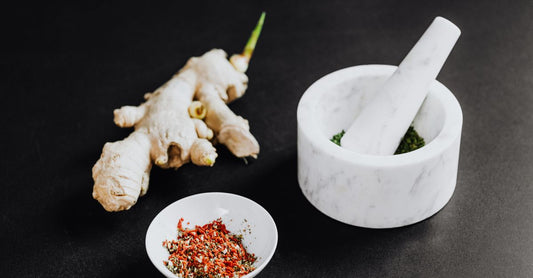 Fresh ginger root next to a glass jar of ginger supplement capsules on a clean, bright surface — illustrating the ginger buying guide UK