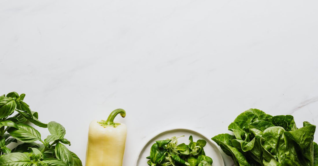 A glass bottle of B9 (folic acid) supplements on a white surface, with a few capsules scattered around it, representing a B9 (folic acid) buying guide UK.