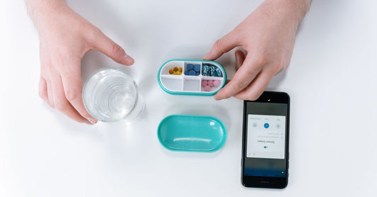 A flatlay of various vitamin organisers and travel kits for supplements, including pill boxes and cooler cases, showing how to choose organisers & travel kits UK.