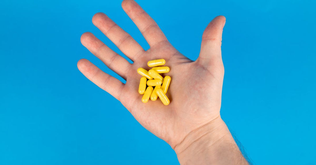 A flatlay of turmeric supplement capsules alongside fresh turmeric root, representing how to choose turmeric UK supplements based on science.