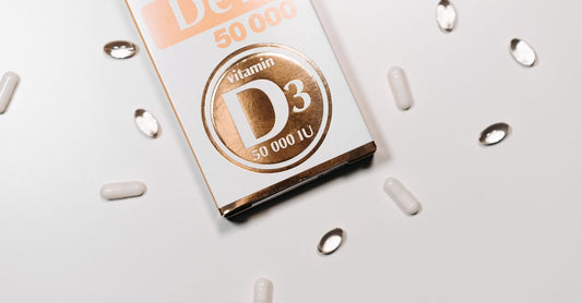 A bottle of vitamin D3 2000 IU tablets placed on a clean white surface with a few tablets scattered nearby, representing a daily supplement routine.