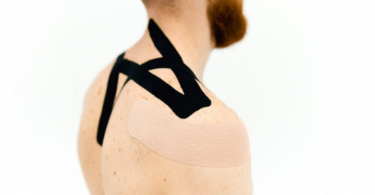 A selection of adhesive bandages including fabric strips, spot plasters and cohesive wraps laid out on a clean surface, illustrating an adhesive bandages buying guide.