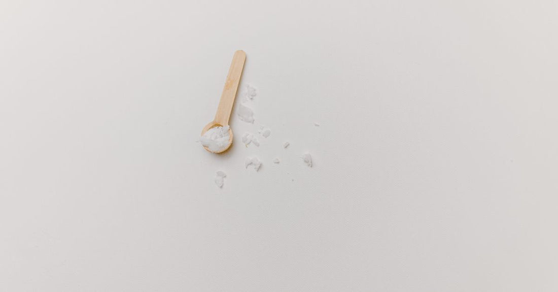Jar of best creatine UK 2026 powder next to a scoop on a white surface
