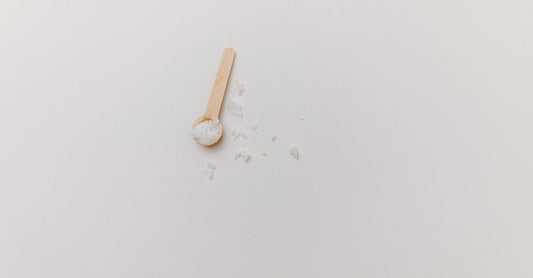 Jar of best creatine UK 2026 powder next to a scoop on a white surface