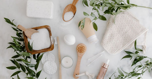 A flatlay of white cotton cleansing cloths and a wooden dish on a marble surface, illustrating a cleansing cloths, swabs & wipes buying guide UK.