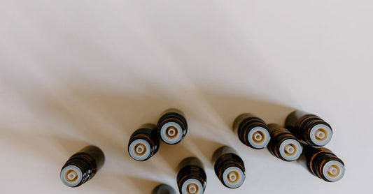A flatlay of amber essential oil bottles with wooden caps, showcasing a variety of essential oil sets available in the UK.