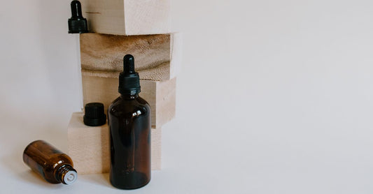 Rows of homeopathic medicine pellets and herbal tincture bottles on a wooden shelf, illustrating how to choose alternative medicine UK.