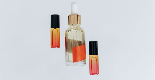 A flatlay of three amber glass aromatherapy oil bottles on a linen cloth, representing our aromatherapy buying guide essentials.