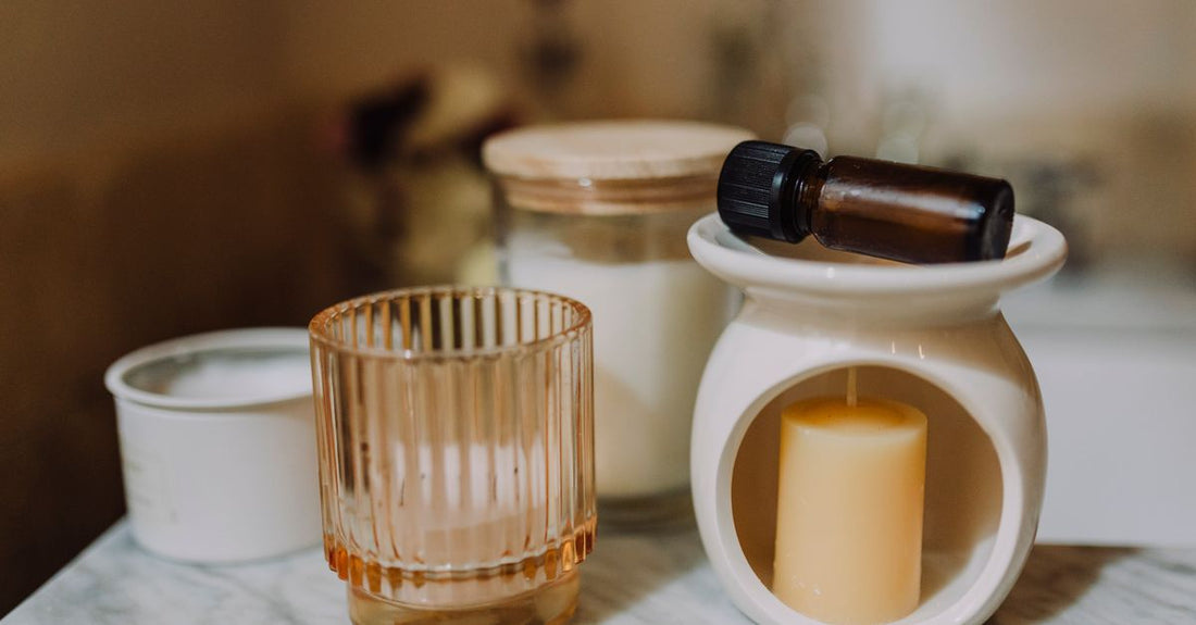 How to choose diffusers UK: a ceramic ultrasonic essential oil diffuser emitting a fine mist on a wooden shelf in a calm, neutral interior.