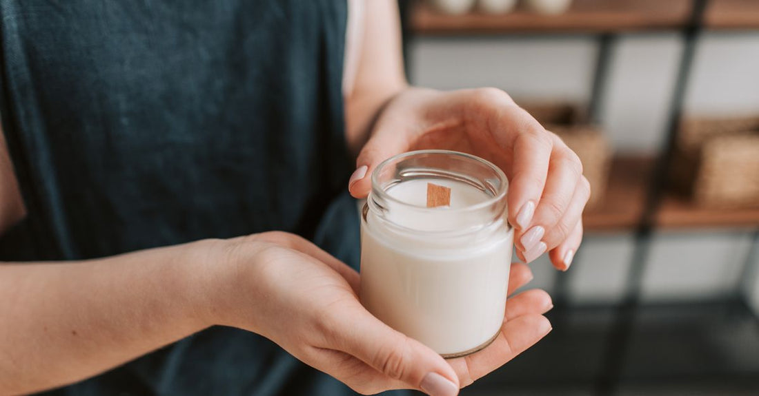 A natural soy wax candle in a clear jar with a clean-burning wooden wick, showcasing how to choose candles UK for a healthier home.