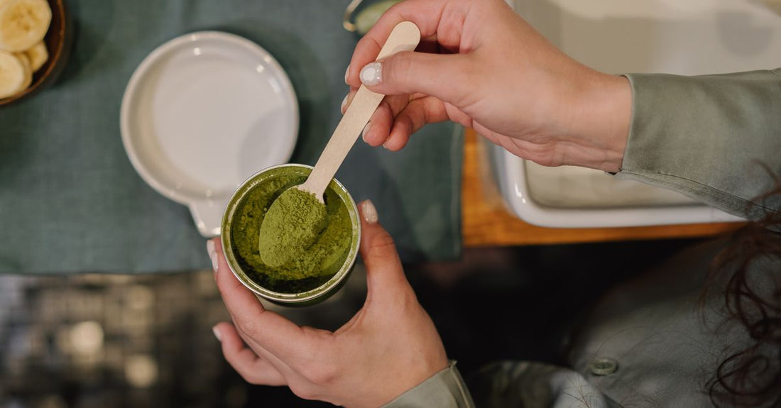 A scoop of pre-workout powder next to a black supplement tub, illustrating how to choose pre-workout UK supplements.
