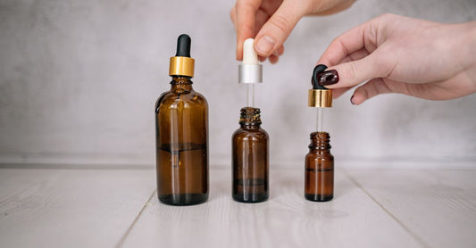 Glass bottle of pure castor oil for hair growth with dropper on a light background