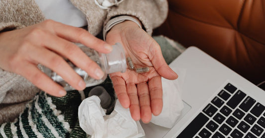 A bottle of selenium supplements for thyroid health on a clean white surface, with a few capsules scattered nearby.