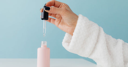 A glass bottle of liquid trace mineral drops next to a small amber jar on a white shelf, illustrating a trace minerals buying guide UK supplement choice.
